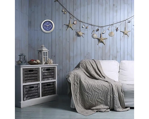 Vardagsrum i maritim stil med byrå, soffa, klocka och dekoration