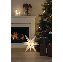 Festlig dekoration med upplyst pappersstjärna, öppen spis, julgran och presenter för en mysig atmosfär.