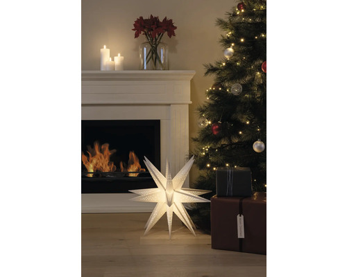 Festlig dekoration med upplyst pappersstjärna, öppen spis, julgran och presenter för en mysig atmosfär.