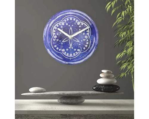 Dekorativ väggklocka med mandalamönster ovanpå en stenstapel