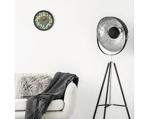 Vardagsrum med soffa, golvlampa och väggklocka