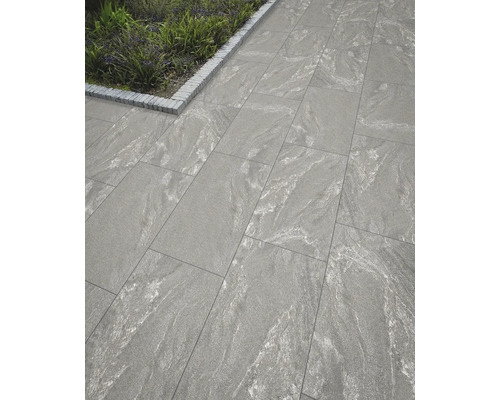 Gångväg med grå betongplattor och gatstenar