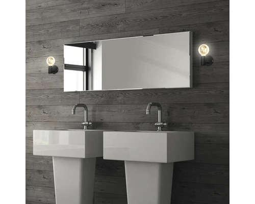 Badrum med två handfat, spegel och lampor