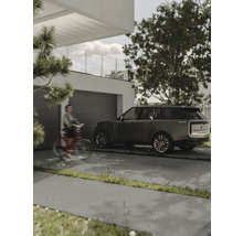 Uppfart med betongstenar, garage och parkerad bil