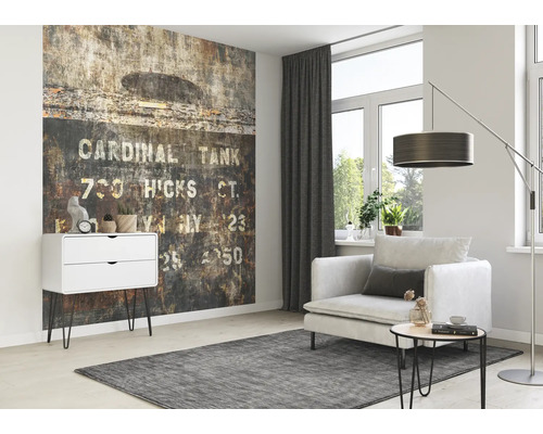 Vardagsrum med mönstrad tapet, fåtölj, golvlampa och byrå