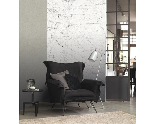 Vardagsrum med fåtölj, golvlampa, sidobord och marmortapet