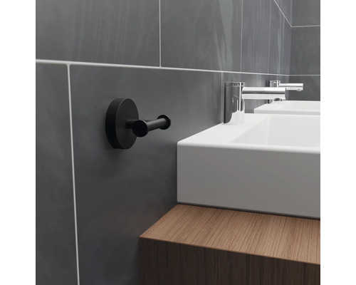 Badrum med handfat, armatur och en svart handdukshängare