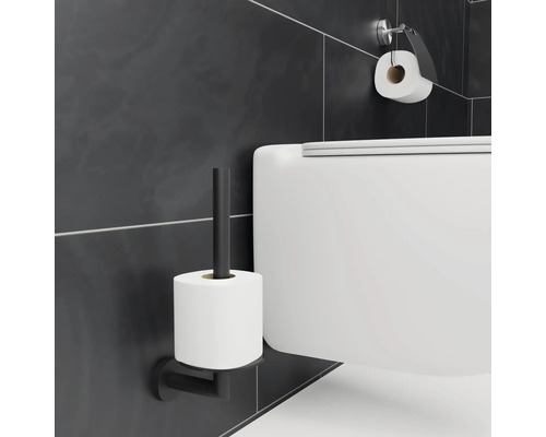 Vägghängd toalett med toalettpappershållare och toalettpapper