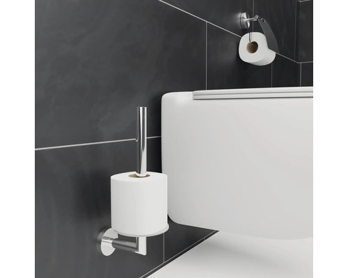 Vägghängd toalettpappershållare av metall med pappersrulle och toalett