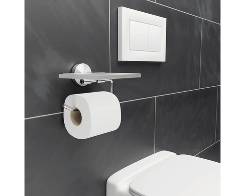 Toalettpappershållare med hylla och spolknapp på väggen