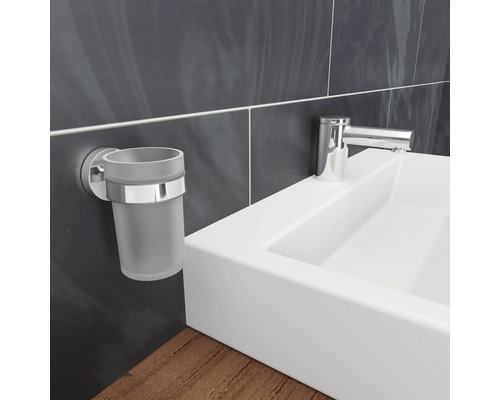 Väggmonterad tandborsthållare bredvid ett handfat