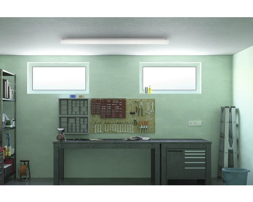 Verkstad med arbetsbänk, hyllor, verktyg och lysrör