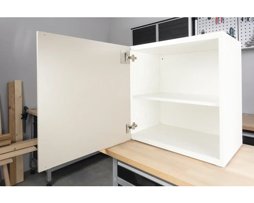 Öppet vitt väggskåp med hyllor och dörr