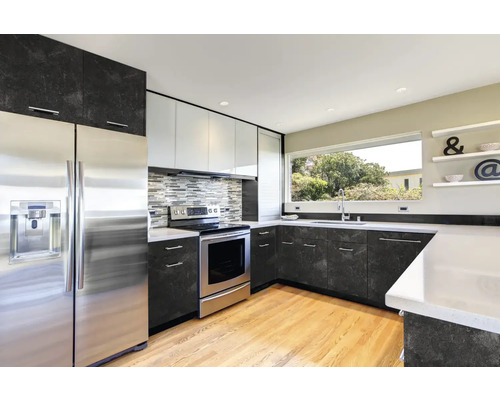 Modernt kök med rostfria vitvaror och mörka bänkskivor.