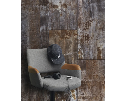 Väggdekoration med plattor i rostdesign, kombinerat med en grå fåtölj och tillbehör