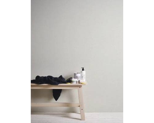 Vägg med tapeter, pall med handduk och vårdprodukter