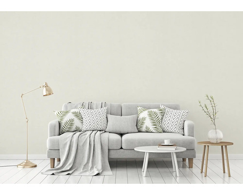 Vardagsrum med soffa, kuddar, filt, bord och golvlampa