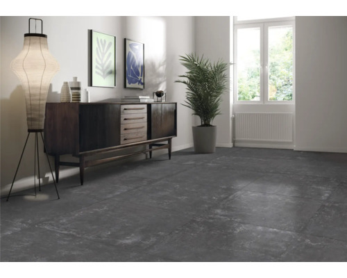 Interiör med mörka plattor, byrå, lampa och krukväxt