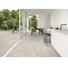 Ljust rum med matbord, kök och stort format på golvplattorna