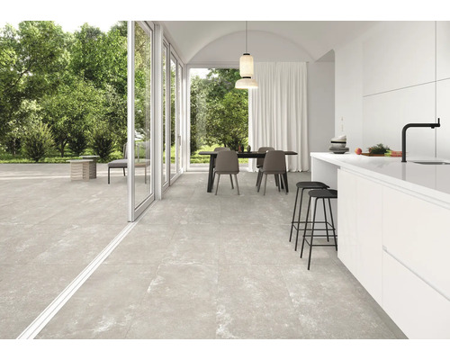 Ljust rum med matbord, kök och stort format på golvplattorna