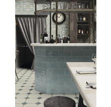 Matsal med kakel, bar, hyllor och sittplatser.