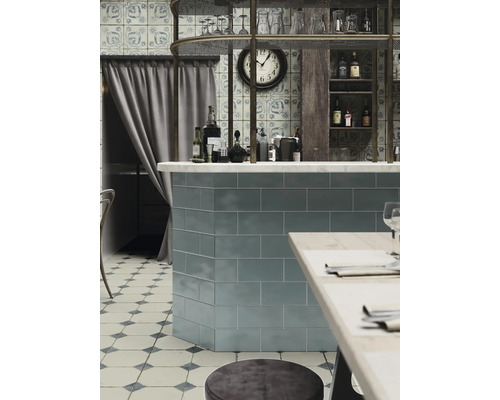 Matsal med kakel, bar, hyllor och sittplatser.