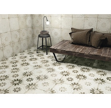 Rumsöversikt med golv- och väggplattor med blommönster, bänk, pall och lampa