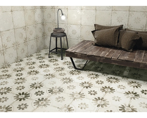 Rumsöversikt med golv- och väggplattor med blommönster, bänk, pall och lampa