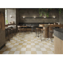 Matsal med schackrutigt kakelgolv, bord och stolar.