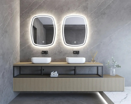 Badrum med två handfat, tvättställsskåp och belysta speglar