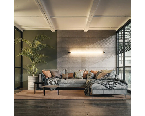 Vardagsrum med grå hörnsoffa, soffbord och krukväxt