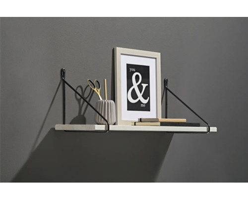 Vägghylla med dekorationer som fotoram, sax och pennhållare