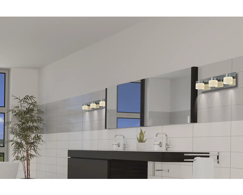 Ljust badrum med handfat, stor spegel och vägglampa