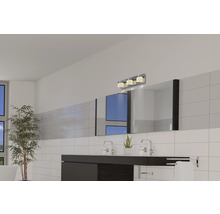 Modernt badrum med handfat, spegel och vägglampa