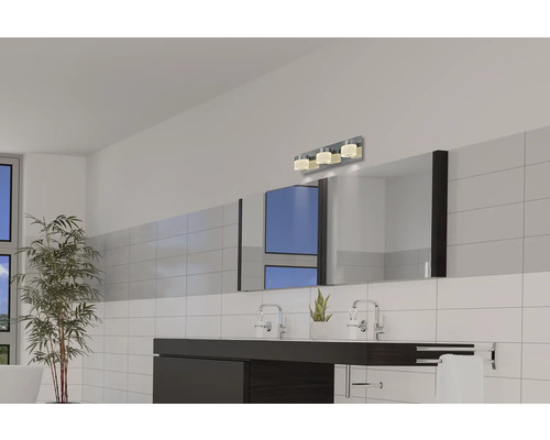 Modernt badrum med handfat, spegel och vägglampa