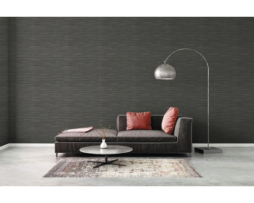 Vardagsrum med mörk tapet, soffa, matta och golvlampa