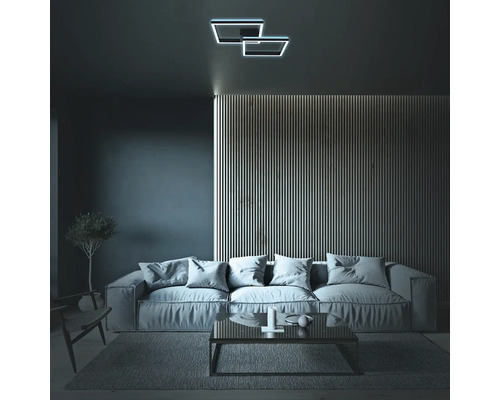 Vardagsrum med soffa, soffbord och taklampa i geometrisk design