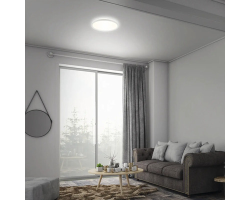 Vardagsrum med taklampa, soffa och fönster