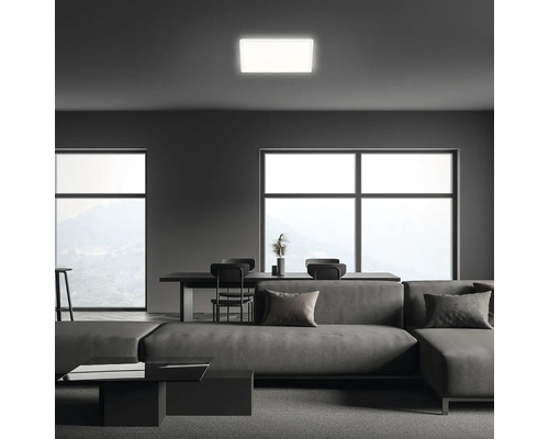 Vardagsrum i modern stil med soffa, matbord och fyrkantig taklampa