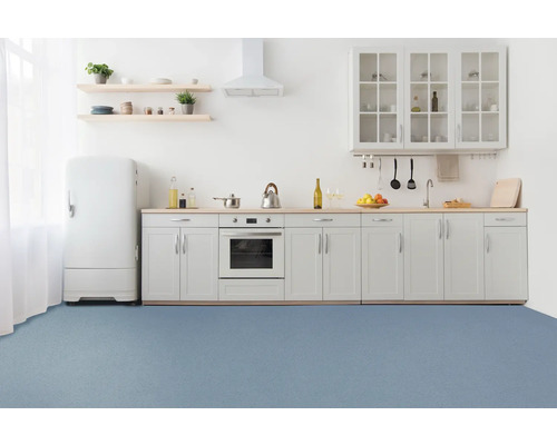 Ljust kök med inbyggda skåp, kylskåp och blå golvyta