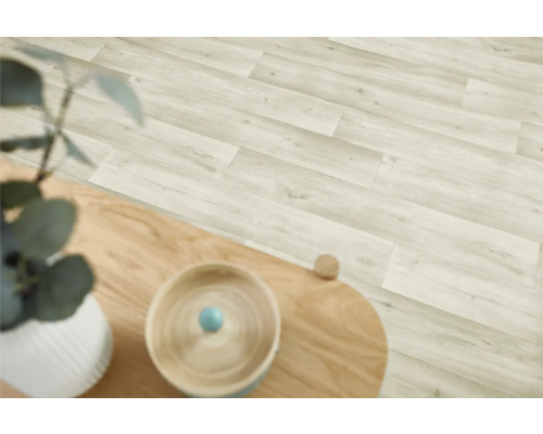 Ljust laminatgolv med träutseende i en interiör.