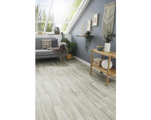 Ljust rum med laminatgolv, soffa, bord och dekorationer under ett takfönster