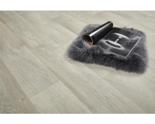 Ljust laminatgolv med matta och tidning