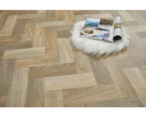 Lagt golv i fiskbensmönster och en öppen tidning på en fällmatta