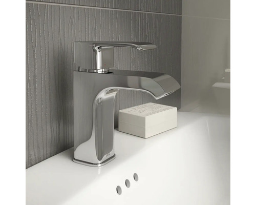 Glänsande tvättställsblandare av metall på ett tvättställ