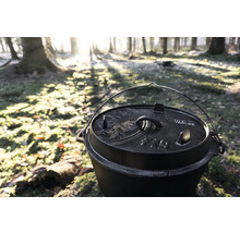 Holländsk ugn i gjutjärn med lock i skogen