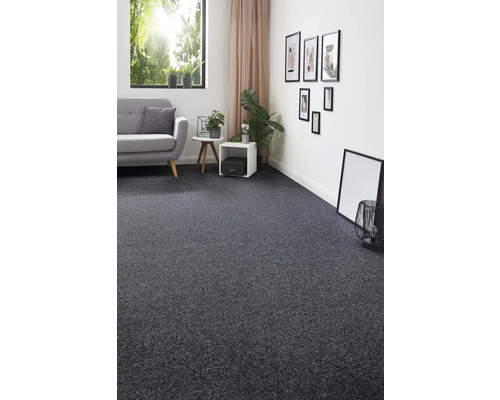 Vardagsrum med grå heltäckningsmatta, soffa och dekorationer