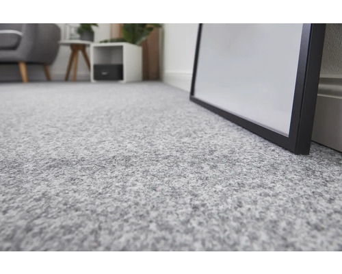 Närbild av en ljusgrå heltäckningsmatta i ett rum.