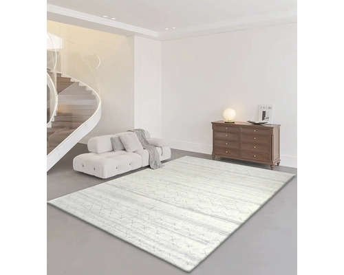 Vardagsrum med soffa, byrå och en ljus mönstrad matta