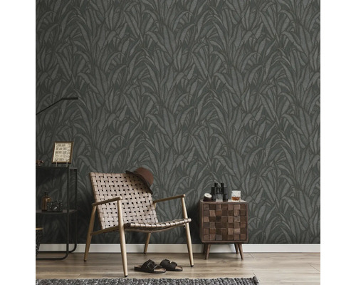 Rum med mörk bladtapet, fåtölj, sängbord och dekoration